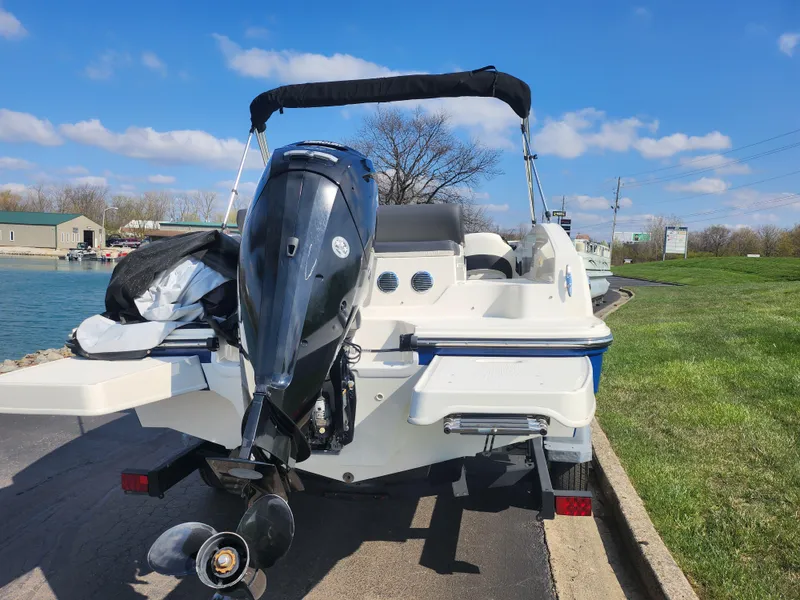 Slide: The Image of 2021 Bayliner DX 2000 boat with outboard motor on a sunny day. - 2
