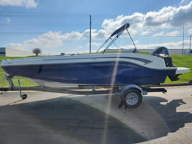 Slide: The Image of 2021 Bayliner DX 2000 boat on trailer under sunny sky. - 4
