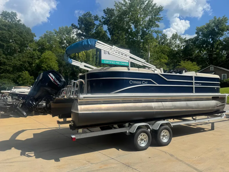 Slide: The Image of 2022 Cypress Cay Seabreeze 232 pontoon boat on trailer, outdoor setting. - 2