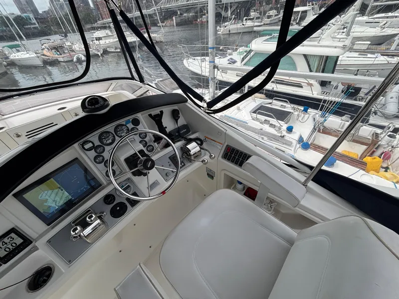 Slide: The Image of 2007 Carver 35 Super Sport helm with navigation controls, docked in a marina. - 10