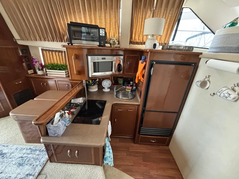 Slide: The Image of 2007 Carver 35 Super Sport yacht kitchen with microwave, sink, and wooden cabinetry. - 17