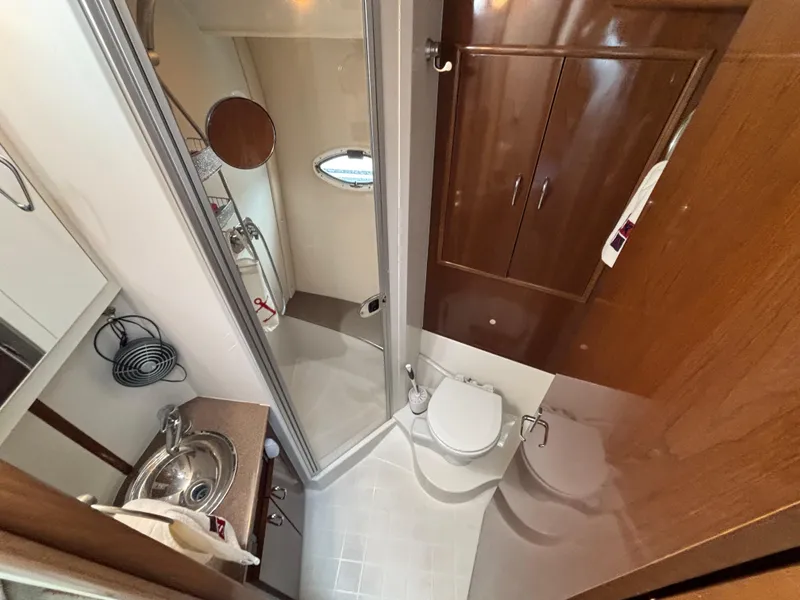 Slide: The Image of 2007 Carver 35 Super Sport yacht bathroom with shower, sink, and wooden cabinetry. - 22