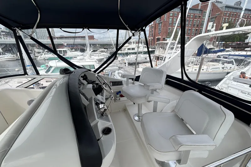 Slide: The Image of 2007 Carver 35 Super Sport yacht cockpit with helm, chairs, and marina view. - 6