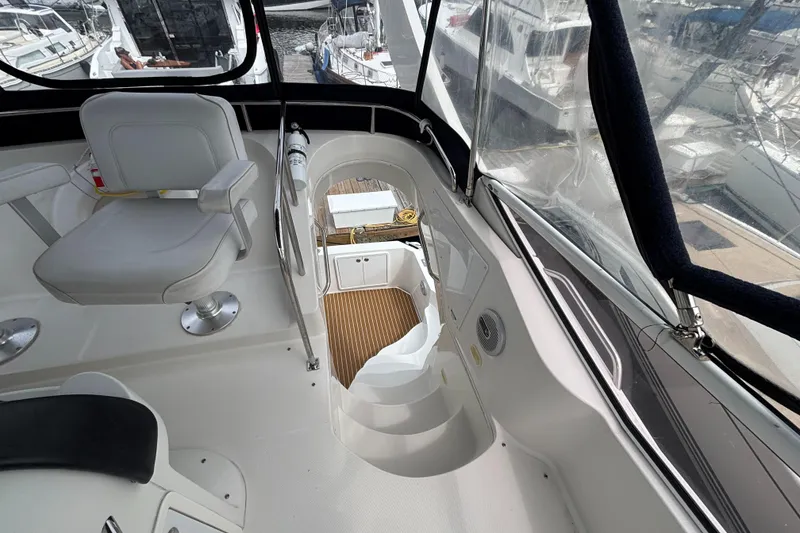 Slide: The Image of 2007 Carver 35 Super Sport yacht interior with seating and stairway, docked at marina. - 7