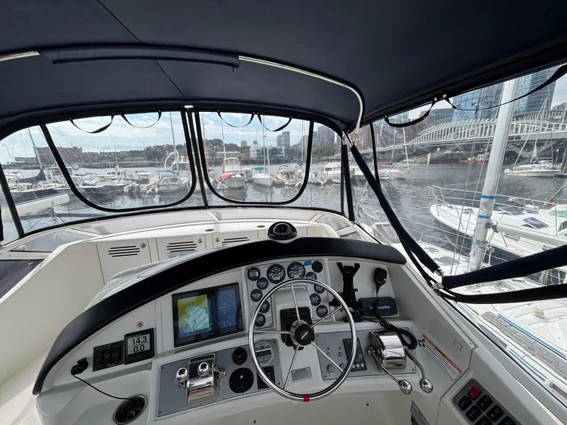 Slide: The Image of 2007 Carver 35 Super Sport helm with marina view, featuring navigation controls and instruments. - 9
