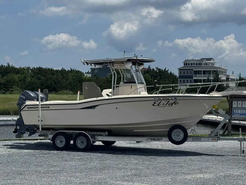 Slide: The Image of 2004 Grady-White Advance 257 boat on trailer, parked outdoors under cloudy sky. - 1