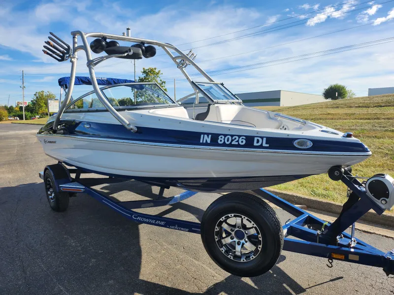 Slide: The Image of 2012 Crownline 195 SS boat on trailer, parked outdoors under a clear blue sky. - 5