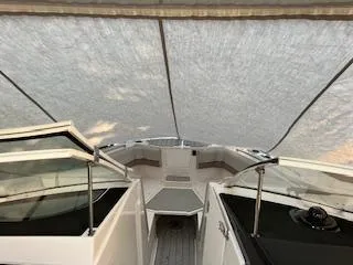 Slide: The Image of 2023 Solara S-250 DC boat interior under canopy, showcasing seating and helm area. - 14