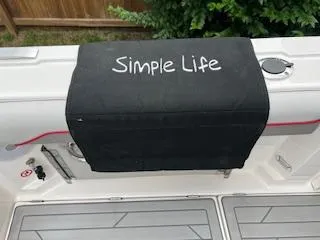 Slide: The Image of 2023 Solara S-250 DC boat with "Simple Life" cover, docked outdoors. - 32