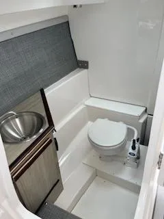 Slide: The Image of 2023 Solara S-250 DC boat interior with compact bathroom, featuring a toilet and sink. - 33