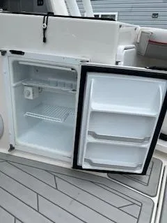 Slide: The Image of 2023 Solara S-250 DC boat with open onboard refrigerator, showcasing interior shelves and storage. - 34