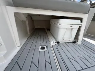 Slide: The Image of 2023 Solara S-250 DC boat interior with storage compartment and cooler on gray deck. - 39
