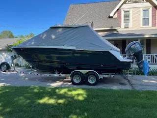 Slide: The Image of 2023 Solara S-250 DC boat on trailer, covered, parked in residential driveway. - 4