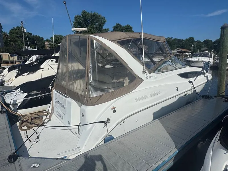 Slide: The Image of 2001 Bayliner 2855 Ciera boat docked at marina under clear blue sky. - 2