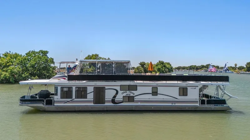 The Image of 2007 American Waterways Widebody houseboat on a calm river, surrounded by trees. - 1