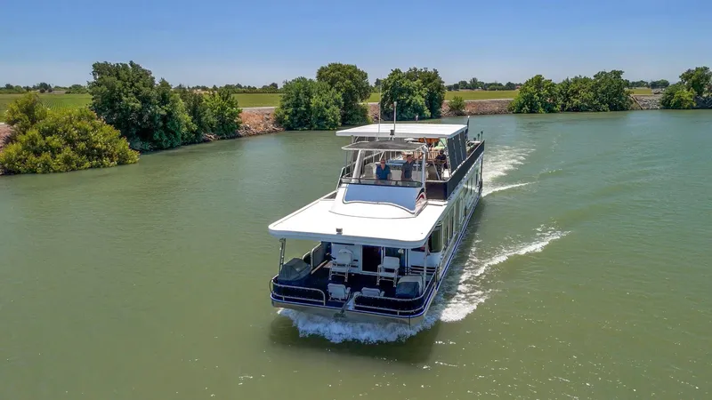 Slide: The Image of 2007 American Waterways Widebody boat cruising on a scenic river with lush greenery. - 14