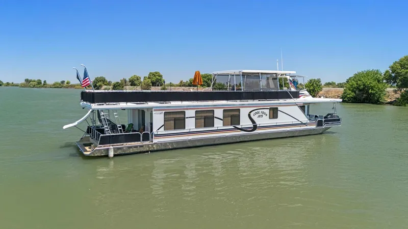 Slide: The Image of 2007 American Waterways Widebody houseboat on a calm river under clear blue skies. - 15