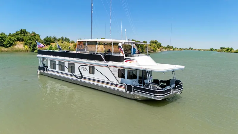 Slide: The Image of 2007 American Waterways Widebody houseboat cruising on a serene river under a clear blue sky. - 17