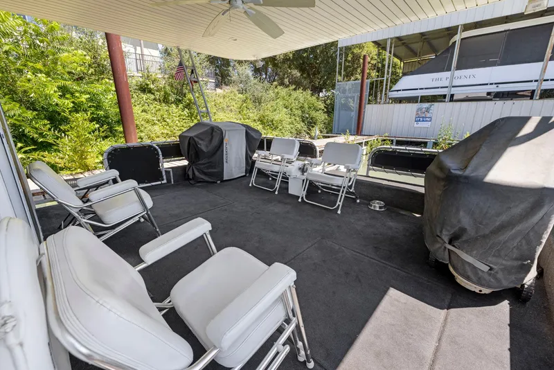 Slide: The Image of Covered deck with white chairs on a 2007 American Waterways Widebody boat. - 20