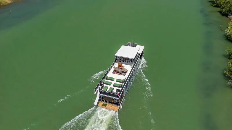Slide: The Image of Aerial view of 2007 American Waterways Widebody boat cruising on a green river. - 34