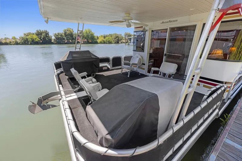 Slide: The Image of 2007 American Waterways Widebody houseboat with covered deck and seating on a serene river. - 37