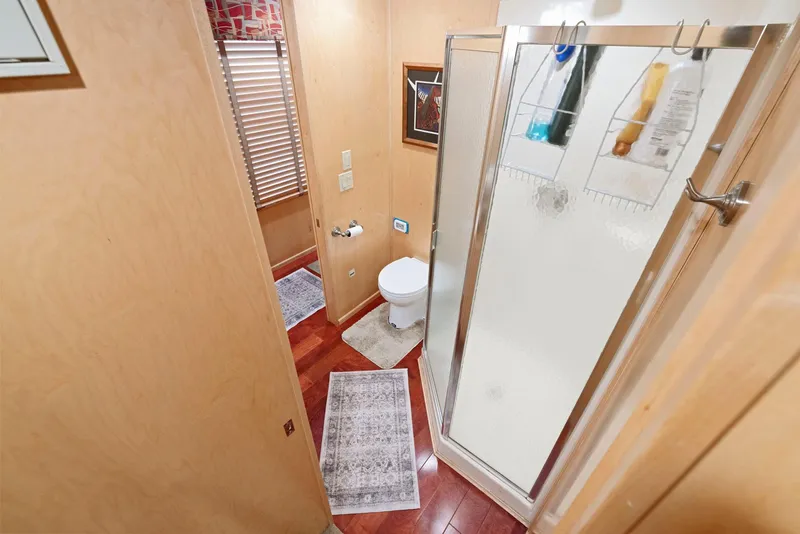 Slide: The Image of Bathroom interior of 2007 American Waterways Widebody with shower, toilet, and wooden flooring. - 43