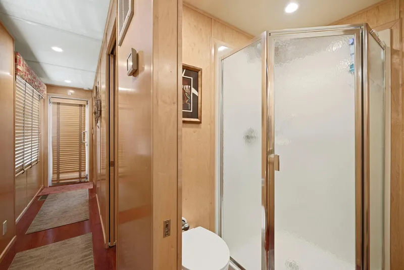 Slide: The Image of Modern bathroom in 2007 American Waterways Widebody, featuring a glass shower and wooden accents. - 45