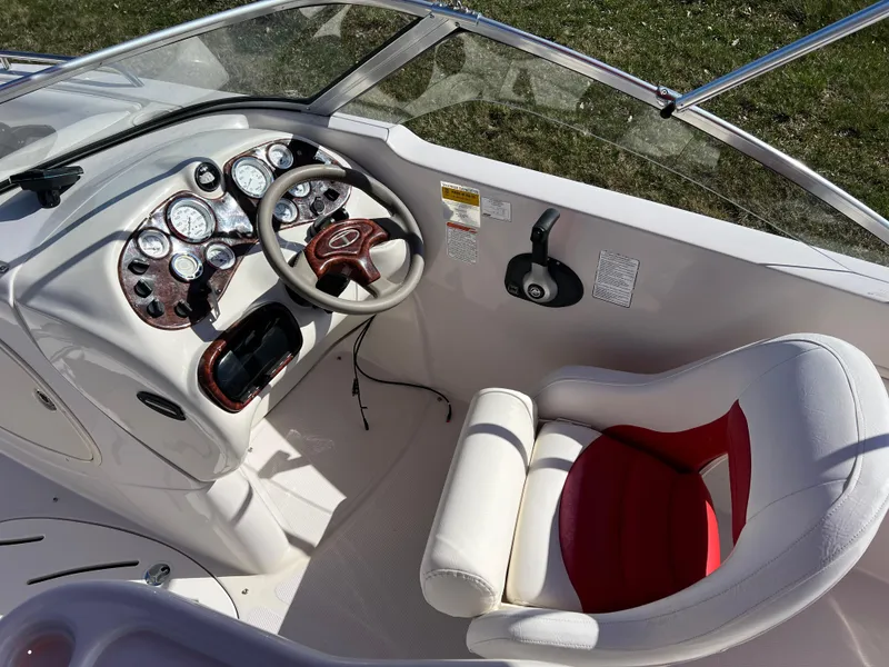 Slide: The Image of 2006 Tahoe 204 WT boat cockpit with steering wheel and gauges, featuring white and red seating. - 16
