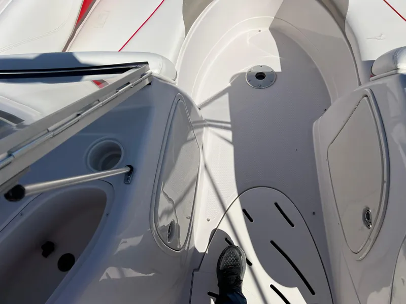 Slide: The Image of 2006 Tahoe 204 WT boat interior with white and red seating, open deck, and foot visible. - 19