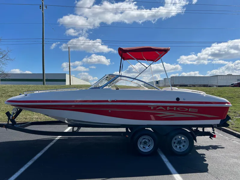 Slide: The Image of 2006 Tahoe 204 WT boat with red accents and canopy on a trailer. - 8