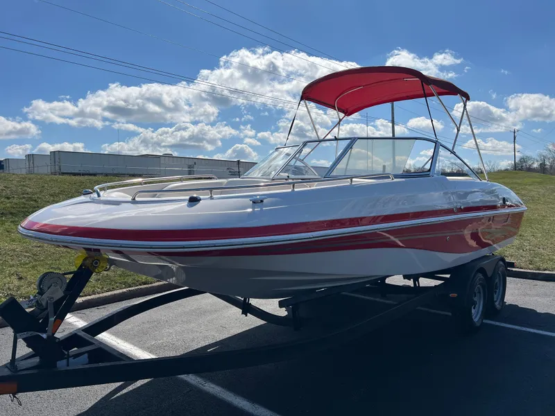Slide: The Image of 2006 Tahoe 204 WT boat with red canopy on trailer, parked outdoors. - 9