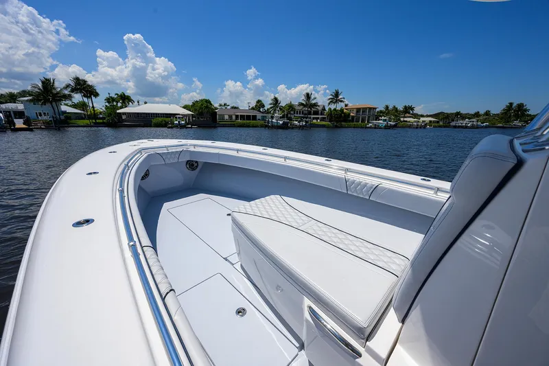 Slide: The Image of 2025 Contender 35 ST boat on a sunny waterfront, showcasing sleek design and spacious seating. - 16