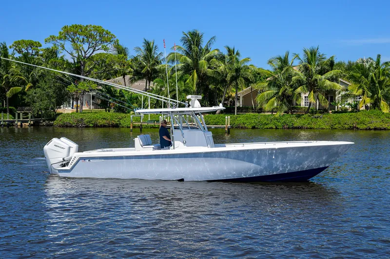 Slide: The Image of 2025 Contender 35 ST boat cruising on a sunny day with palm trees in the background. - 2