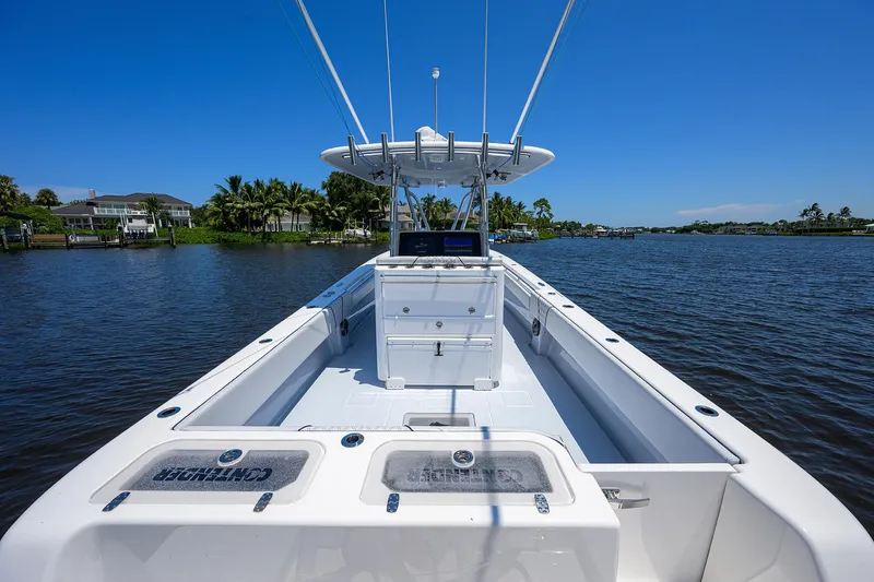 Slide: The Image of 2025 Contender 35 ST boat on a calm river under clear blue skies. - 29