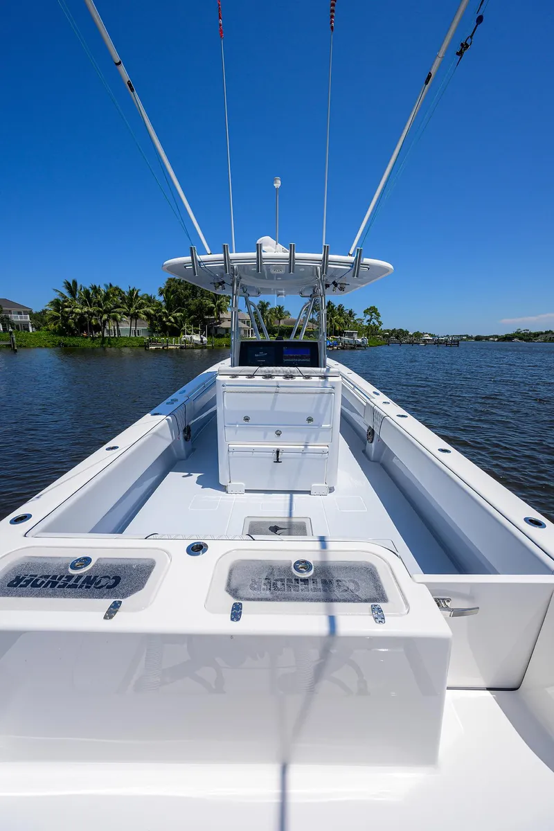 Slide: The Image of 2025 Contender 35 ST boat on a sunny day, docked by a scenic waterfront. - 32