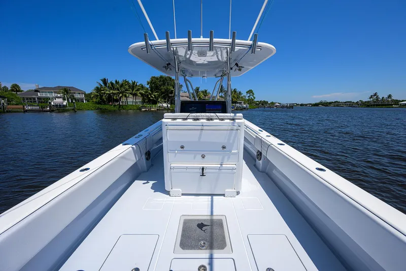 Slide: The Image of 2025 Contender 35 ST boat on calm water, clear sky, and lush shoreline. - 33