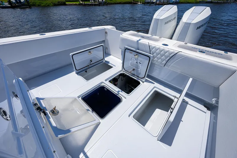 Slide: The Image of 2025 Contender 35 ST boat deck with open storage compartments and dual Mercury engines. - 37