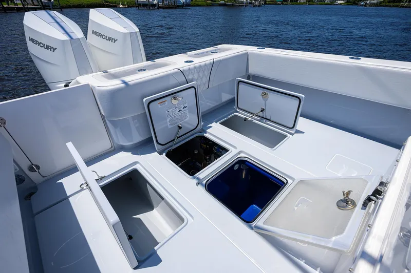 Slide: The Image of 2025 Contender 35 ST boat deck with open storage compartments and Mercury engines. - 39