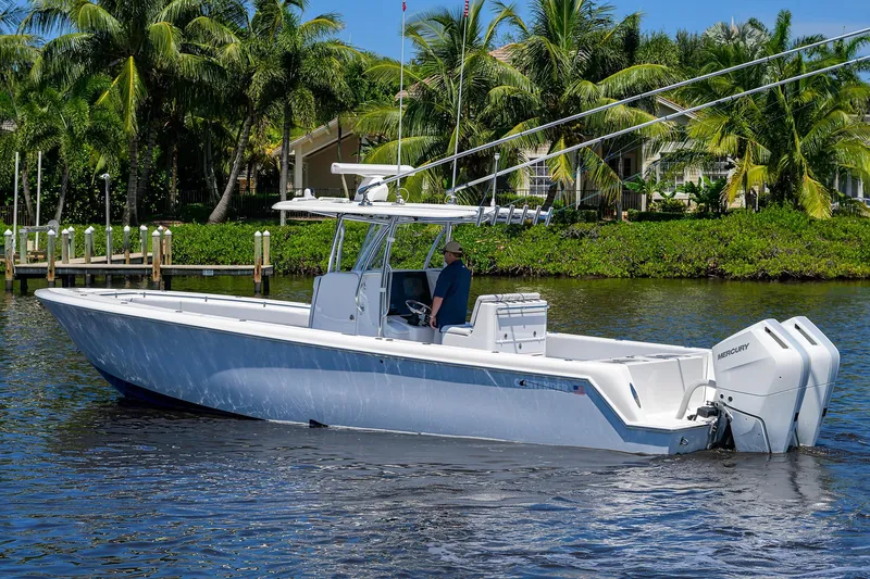 Slide: The Image of 2025 Contender 35 ST boat cruising on a sunny day, surrounded by lush greenery. - 4