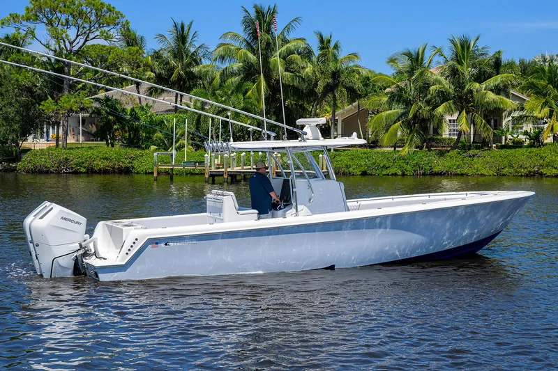 Slide: The Image of 2025 Contender 35 ST boat cruising on a scenic waterway with palm trees. - 7