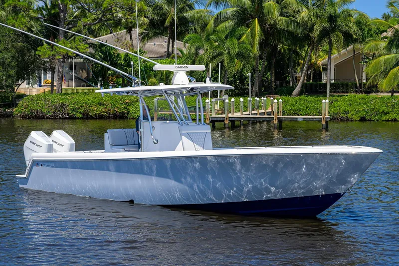 Slide: The Image of 2025 Contender 35 ST boat on water, surrounded by lush greenery and dock. - 8