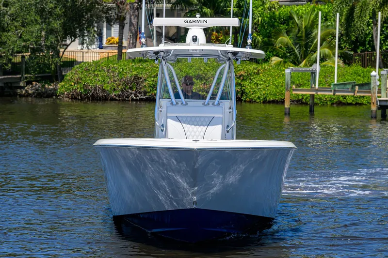 Slide: The Image of 2025 Contender 35 ST boat cruising on a sunny day with lush greenery in the background. - 9