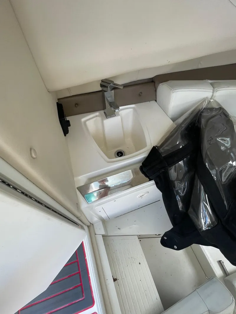 Slide: The Image of 2018 Striper 200 Walkaround boat interior with sink and seating area. - 11