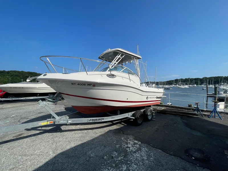 Slide: The Image of 2018 Striper 200 Walkaround boat on trailer by marina. - 15