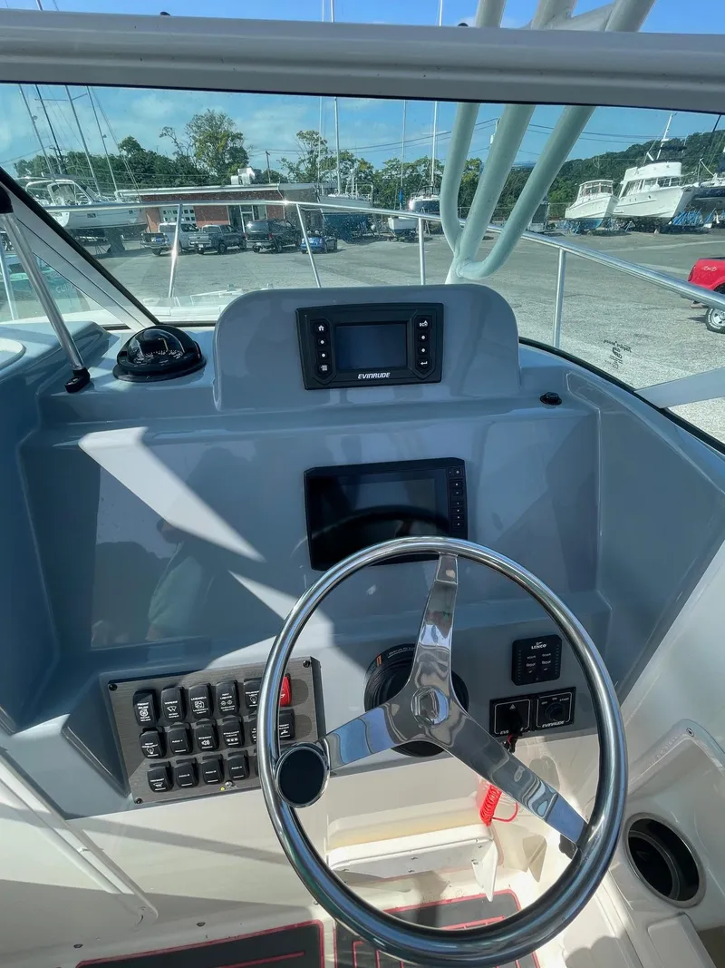 Slide: The Image of 2018 Striper 200 Walkaround boat dashboard with steering wheel and navigation controls. - 9