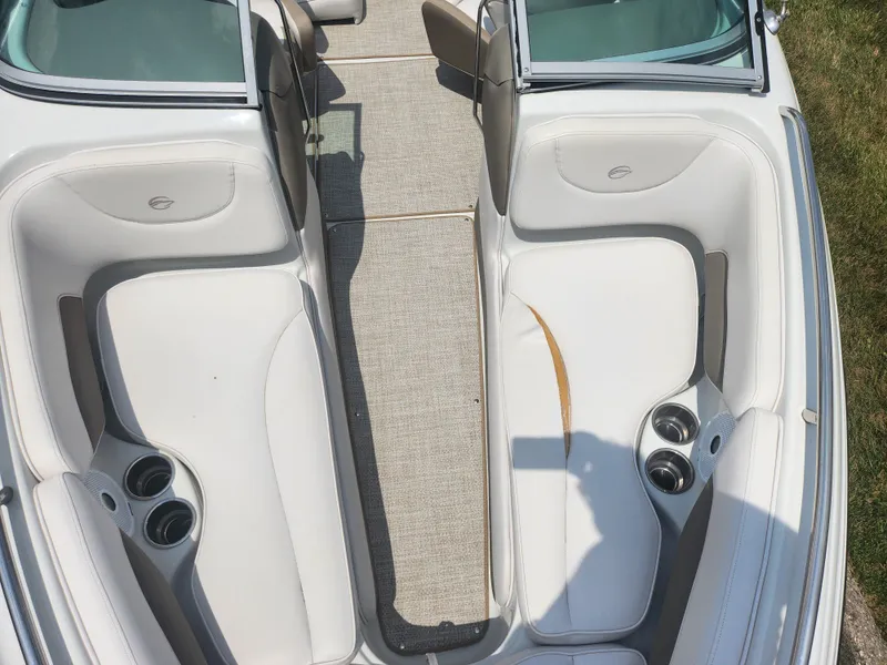 Slide: The Image of 2014 Crownline 21 SS boat interior with white seating and cup holders. - 17