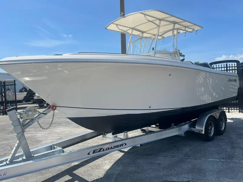Slide: The Image of 2022 Sailfish 242 CC boat on trailer under clear blue sky. - 2