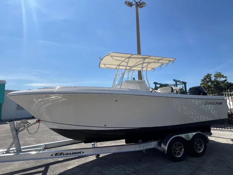 Slide: The Image of 2022 Sailfish 242 CC boat on EZ Loader trailer under clear blue sky. - 3