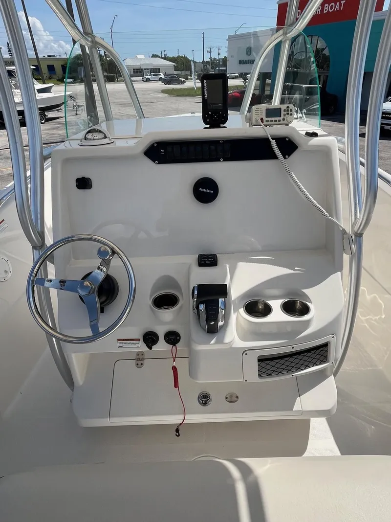 Slide: The Image of 2022 Sailfish 242 CC boat console with steering wheel, controls, and cup holders. - 5