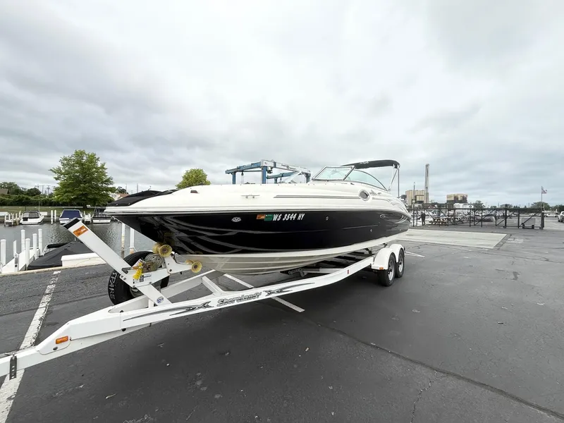 Slide: The Image of 2006 Sea Ray 240 Sundeck boat on trailer at marina, overcast sky. - 3